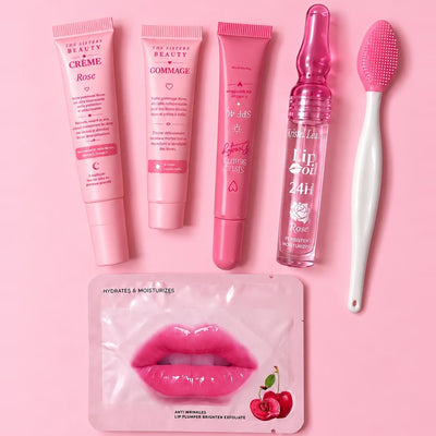 Kit Complet Lèvres Rosées : la Crème Rose, le Gommage, le tube SPF 40, un gloss lip oil à la rose, la brosse exfoliante et un masque à lèvres Cherry sur fond rose